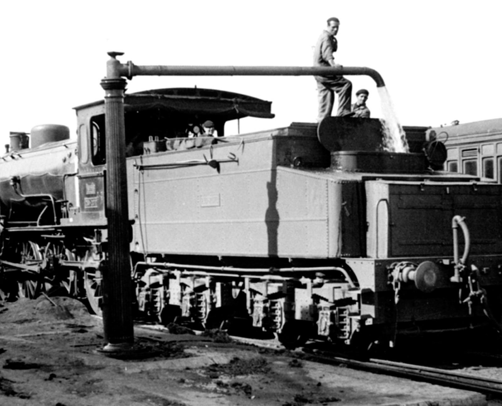 Ferroviarios llenando el tanque de la locomotora de agua con la grúa hidráulica. Abr-1953. Foto: K. Wyrsch. <i>AHF-MFM</i>