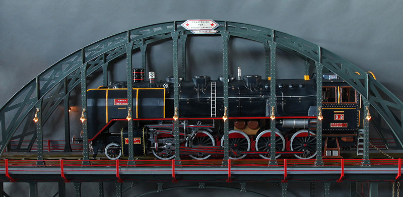 Juguete de locomotora de vapor sobre puente metálico